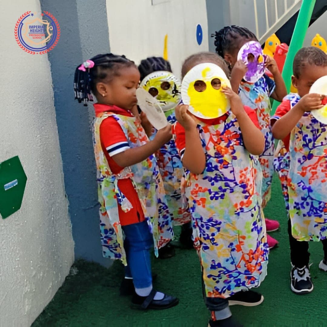 Nursery children holding up the smiling faces they made from paper plates